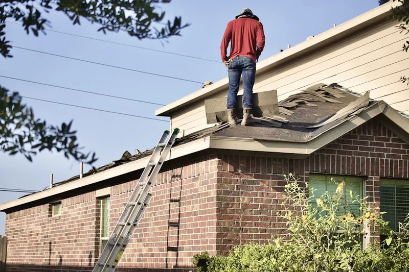 Professional roofer working on a residential roof in Claiborne
